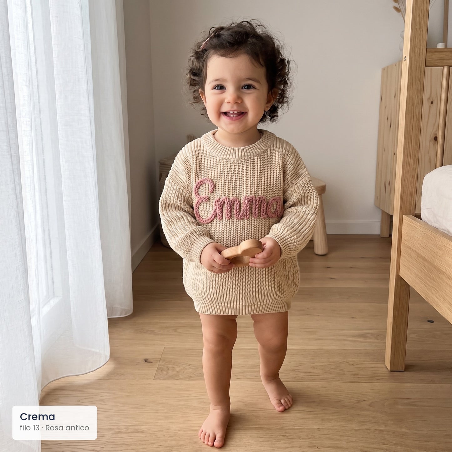 Bambina con maglioncino crema e nome Emma ricamato in rosa antico