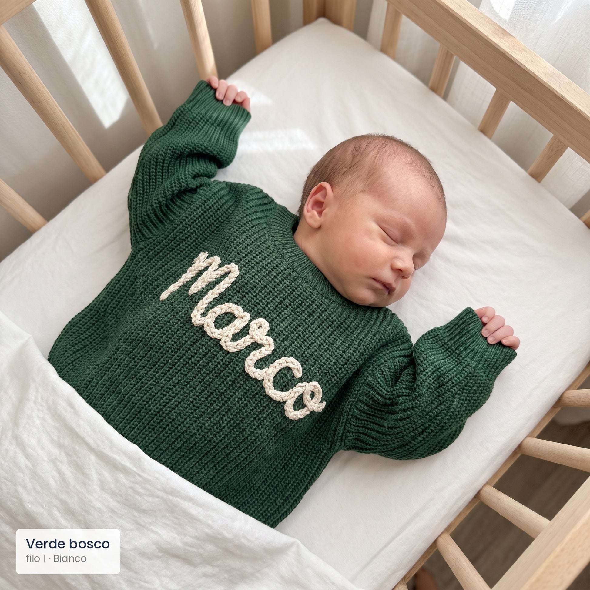 Neonato nella culla con maglioncino verde bosco e nome Marco ricamato